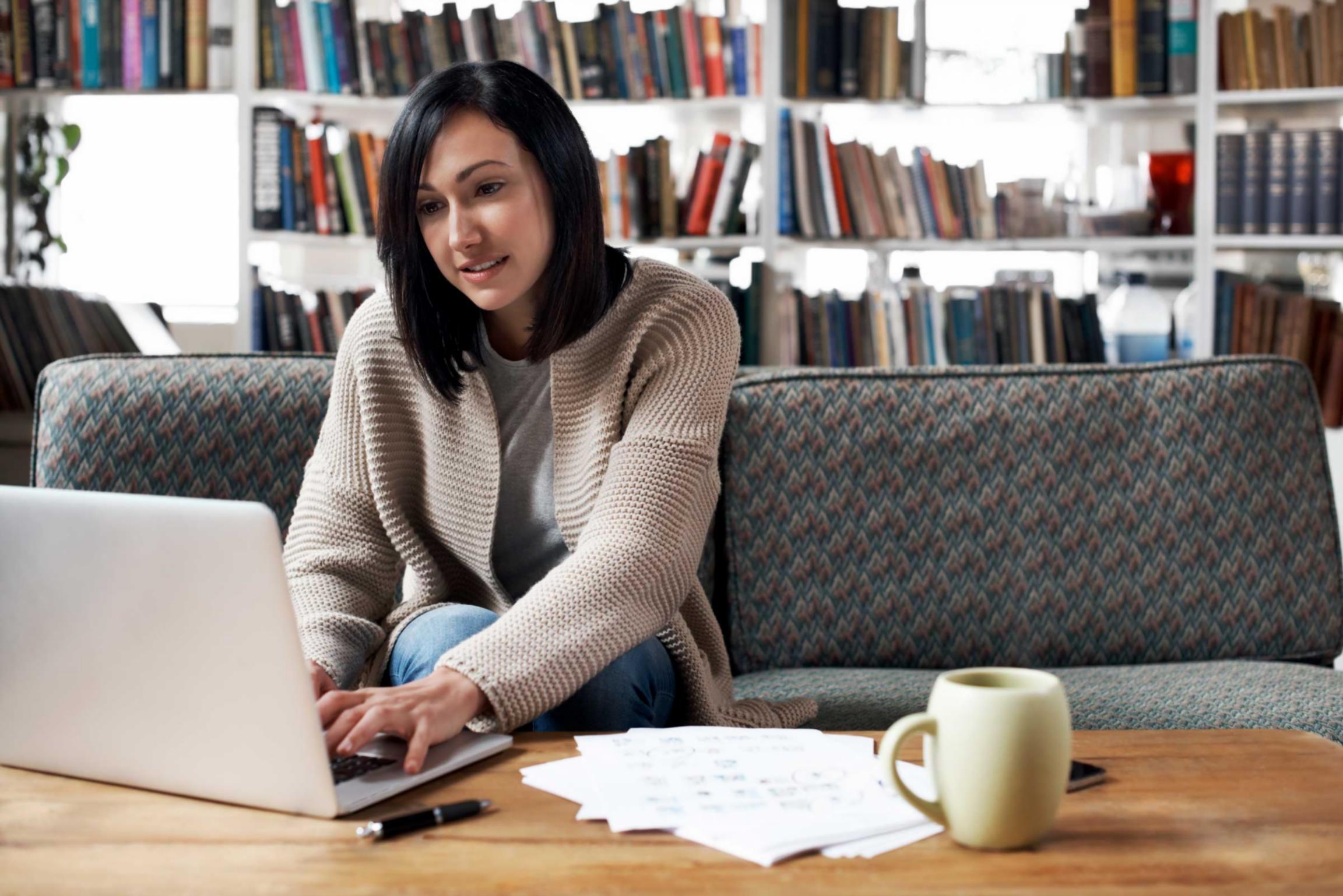 Professional reviewing consolidated budget reports with multiple data sources organized on desk